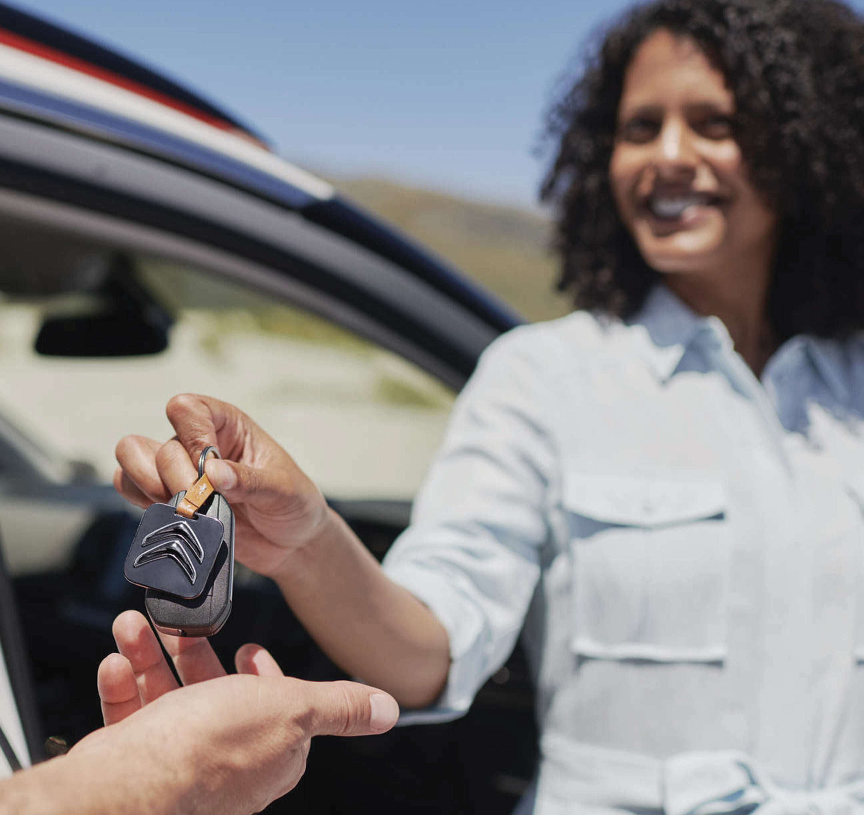Молода жінка передає клієнту ключі від автомобіля Citroën
