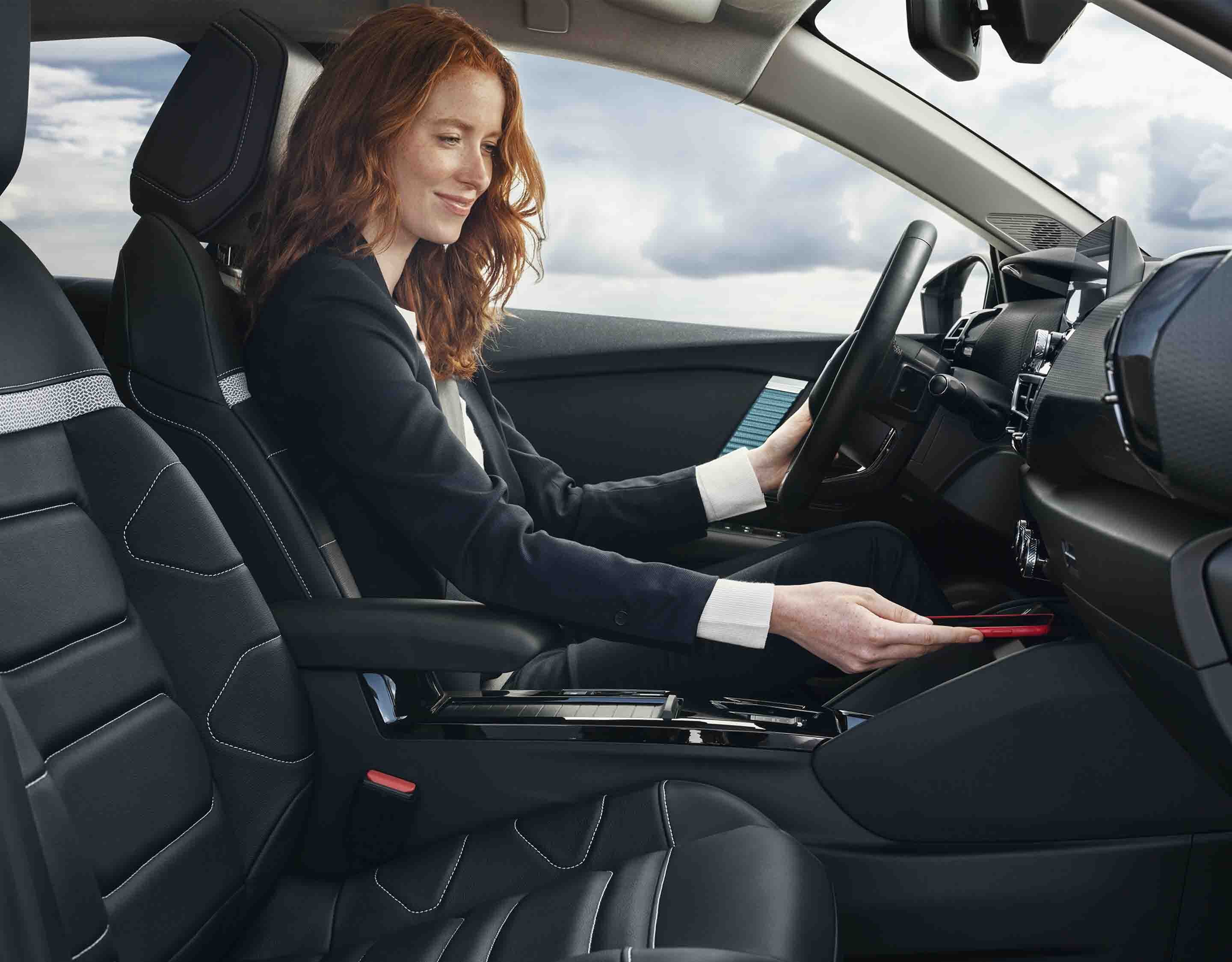 Жінка-водія користується консоллю у салоні Citroen C4